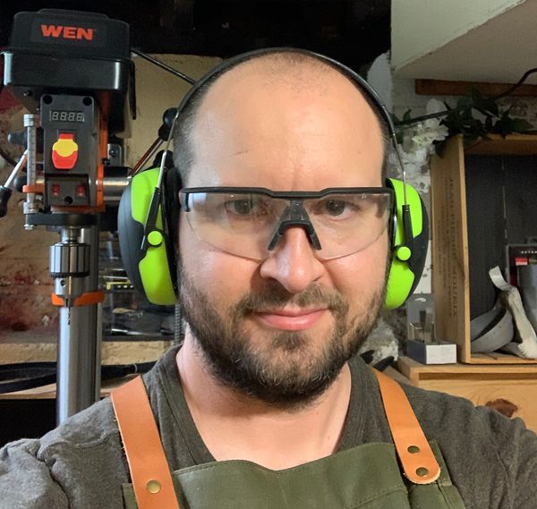 Adam Luptak, wearing safety glasses and hearing protection, in his basement workshop