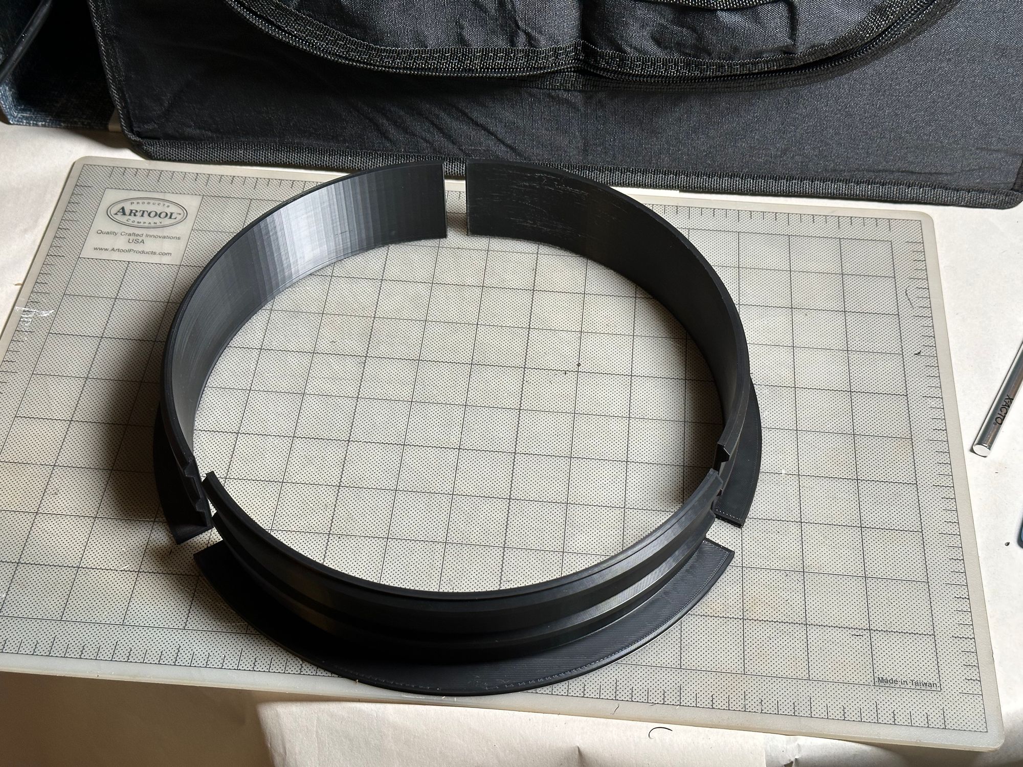 All three pieces of the duct ring, printed, trimmed, and arranged on a cutting surface.
