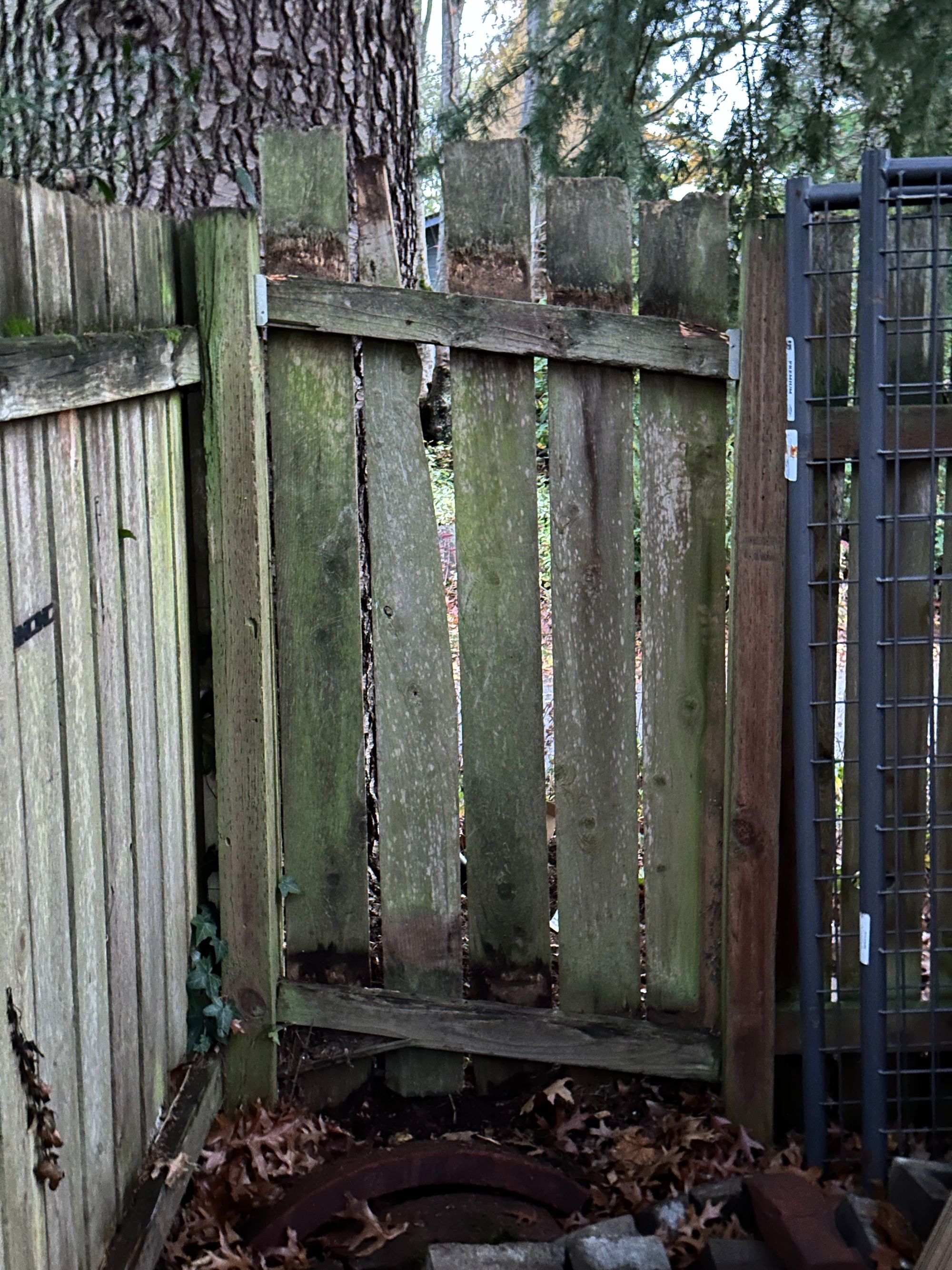 The section of the fence, with slats reorganized and secured with screws, and the top rail secured to posts with brackets